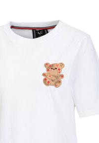 Weißes Baumwoll-T-Shirt mit einem grafik eines sandfarbenen Teddybären mit roten Akzenten und Formen. Der Kragen hat ein gestreiftes Innenband.