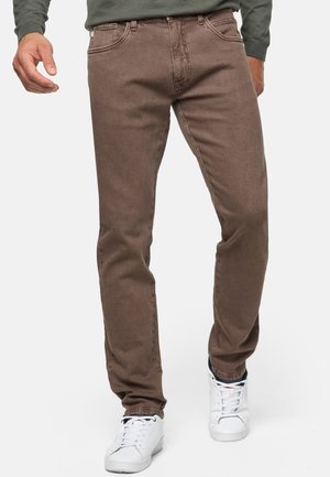 Brown cotton jeans with a straight-leg design, five pockets, and subtle texture, paired with white sneakers.
