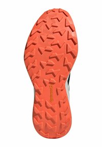 Suela de zapato de trail running con un patrón de textura; media suela de goma naranja; contraste superior negro; branding "Continental" visible.