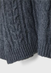 Grå kabelstickad tröja med tjocka ribbade muddarna, ett texturerat mönster och mjukt ullmaterial, som betonar värme och hantverk.