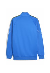 Sininen urheilujuoksujakku, jossa on pystykaulus, pitkät hihat ja kontrastivärinen kuvioitu viimeistely hartioiden kohdalla. Tasainen pinta, ilman näkyvää brändäystä.