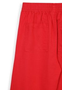 Rote Baumwollhosen mit elastischem Bund, zwei Gesäßtaschen und glatter Textur. Das Design ist schlicht mit geradem Schnitt.