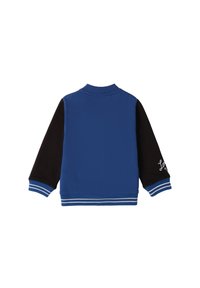 Chaqueta azul y negra con mangas largas, cuello y puños acanalados. Presenta rayas blancas en los puños y un detalle bordado en la manga.