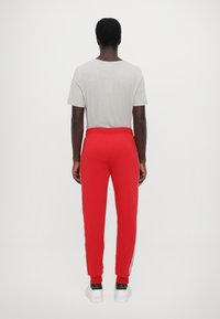 EA7 Emporio Armani PANTALONI - Treniņtērpa apakšdaļas - salsa