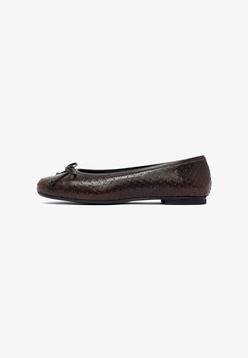 Chaussure plate marron avec un design en cuir tissé, bout arrondi, petit nœud décoratif et semelle extérieure en caoutchouc noir de faible hauteur.