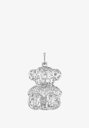 Colgante plateado en forma de oso con tipografía recortada intrincada, palabras dispuestas en varias orientaciones a lo largo de su cuerpo.