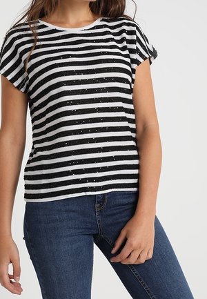 Gestreiftes Kurzarmoberteil in Schwarz und Weiß mit weicher Textur. Es verfügt über horizontale Streifen und dezente Verzierungen. Kombiniert mit blauer Jeans.