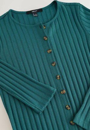 Türkiser gerippter Pullover mit Rundhalsausschnitt, Knopfschluss und langen Ärmeln, flach auf einem neutralen Hintergrund ausgelegt.