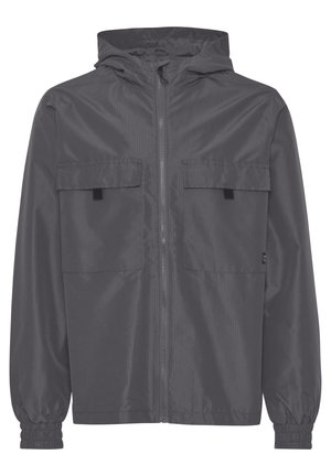 Chaqueta con capucha gris hecha de material ligero, que cuenta con dos bolsillos frontales, puños elásticos y un cierre de cremallera completa con una textura sutil.