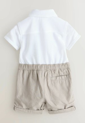 Valge lühikeste varrukatega polosärk, mida täiendab beežid lühikesed püksid, millel on elastne vöökoht ja tagatasku, üles keeratud varrukaotsad, kerge kangas.