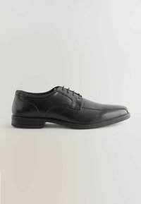 Zwarte leren dockerschoenen met een spitse neus, vetersluiting en een gladde afwerking. Beschikt over een platte rubberen zool voor grip en comfort.
