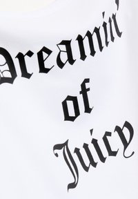 Tessuto bianco con bold caratteri neri che recitano "Sognando di Juicy." Il testo presenta un font stilizzato ispirato al gotico.