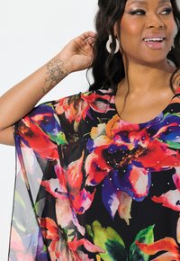Fließendes Blumenshirt mit schwarzem Grundton und lebhaften roten, blauen und grünen Blumenmustern, akzentuiert durch verstreute Strasssteine.