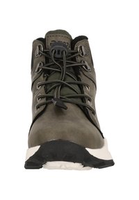 Scarponcino da trekking verde oliva con tomaia sintetica, finitura testurizzata e suola in gomma nera. Presenta occhielli metallici e lacci piatti per una vestibilità sicura.