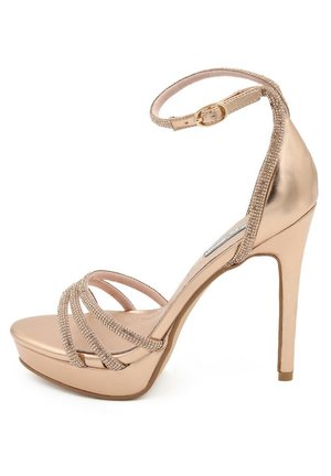 Sandalo con tacco alto in oro rosa metallico, dotato di cinturino alla caviglia, con bande incrociate luccicanti e suola a piattaforma per un'altezza extra.