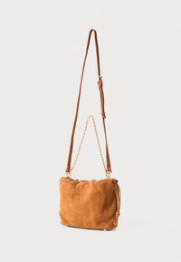 Smeđi suedni crossbody torba s teksturiranom površinom, podesivim remenom i zlatnim lancem kao ukrasom, s nabranim stranama i zaobljenim oblikom.