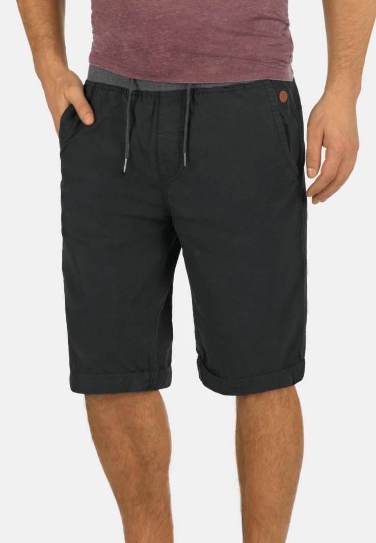 Shorts noirs mi-cuisses avec ourlets retroussés, fabriqués en tissu léger, dotés d'une taille élastique avec cordon de serrage et de poches latérales.