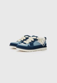 Mörkblå sneakers med mocka och mesh-material, ljusblå accenter, tjocka skosnören och en texturerad vit gummisula.