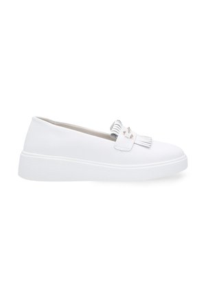 Weiße Slip-On-Schuhe mit einer strukturierten Gummisohle, die mit Fransen und kleinen metallischen Akzenten an der Vorderseite versehen sind. Obermaterial aus glattem Kunstleder.