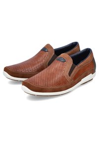 Mocassins en cuir marron avec un design perforé, des panneaux élastiques sur les côtés et une semelle en caoutchouc blanche. Des accents texturés rehaussent l'apparence générale.