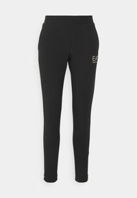 Pantalon jogger noir coupe slim avec ceinture élastique et petit logo « "EA7 Emporio Armani" » sur la cuisse gauche, présenté sur fond blanc.