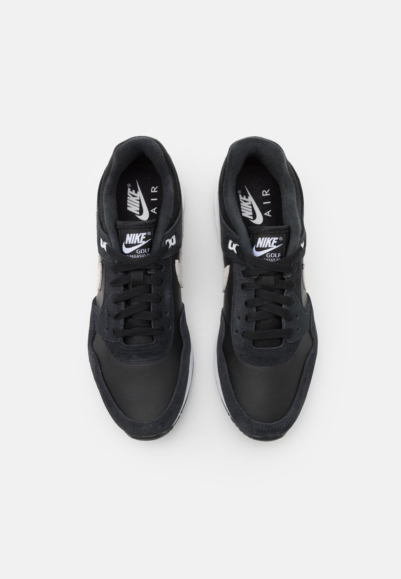 Schwarze Leder- und Wildledersneaker mit runder Spitze, flachen Schnürsenkeln und grauen Akzenten. Mit Nike-Branding auf der Zunge und der Seite.