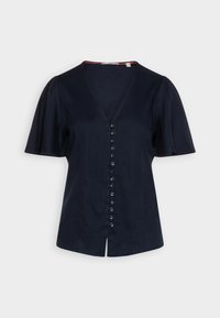 Blusa blu navy a maniche corte con scollatura a V profonda, chiusura frontale con dieci bottoni e orlo leggermente svasato. Tessuto dalla texture liscia.