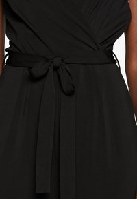 Robe noire avec un design portefeuille. Texture de tissu lisse. Comprend une ceinture nouée à la taille. Silhouette simple et classique. Pas de motifs visibles.