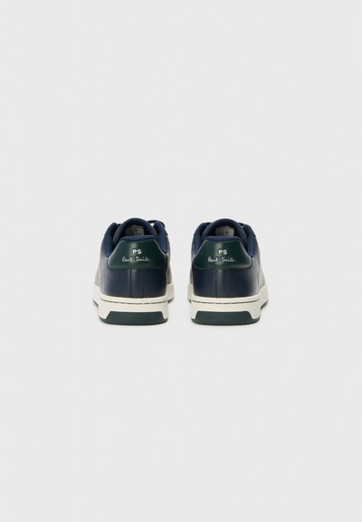 Marinblå lädersneakers med vit sula, med gröna hälaccenter och präglad logotyp. Slät yta med minimalistisk design.