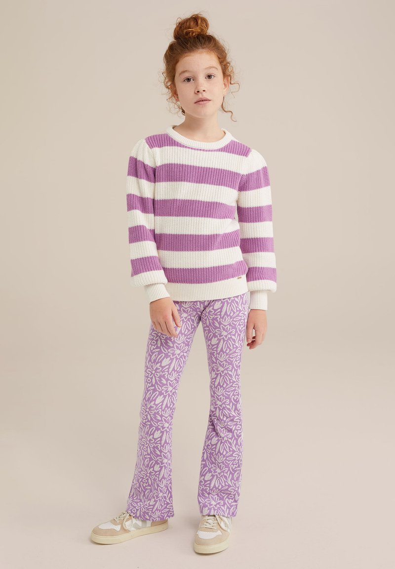 Maglione lavorato a maglia con righe bianche e lavanda, abbinato a pantaloni a campana lavanda con un motivo floreale. Le sneakers completano l'outfit.