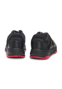 Scarpe sportive nere dal design elegante, con tomaia in mesh texturizzato, collarino imbottito e suola in gomma rossa per una migliore aderenza.