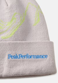 Gorro de punto gris claro con diseño abstracto en verde y bordado en azul "PeakPerformance" en el puño. Textura suave y forma ajustada.