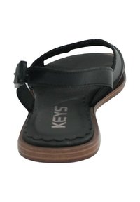 Sandalo nero con suola piatta, dotato di una soletta testurizzata e una cinghia elegante. Logo evidente sulla soletta e chiusura con fibbia sulla cinghia.