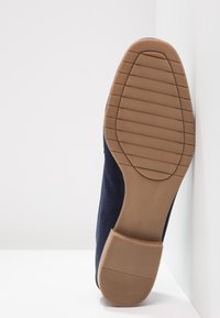 Granatowe zamszowe buty męskie z gumową podeszwą, z teksturowaną powierzchnią i gładkim obcasem. Podeszwa posiada poziome rowki dla lepszej przyczepności.