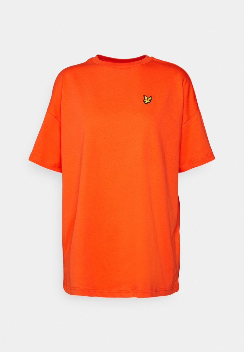 T-shirt à manches courtes de couleur orange vif avec un logo d'oiseau jaune et noir de petite taille sur la poitrine gauche.