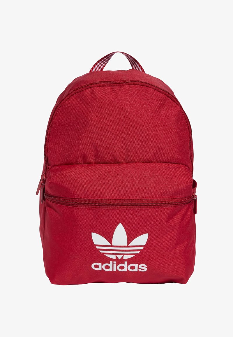 Zaino in tessuto rosso con forma arrotondata, tasca frontale con zip e logo Adidas bianco ben visibile nella parte anteriore inferiore. Spallacci a righe verticali.
