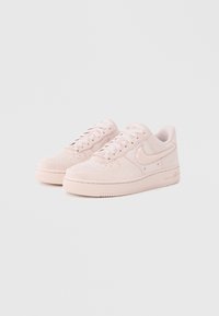 Heledalt roosad seemisnahast tossud madala säärega, ümarate varvaste ja tekstureeritud tallaga. Omavad perforatsioone ja läikivat Swooshi logo.