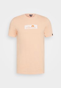 Meruňkový bavlněný tričko s krátkými rukávy, na přední straně s bílým obdélníkovým logem s oranžovými a žlutými akcenty a s malým logem na rukávu.