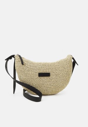 Proplétaná béžová crossbody kabelka ve tvaru půlměsíce s nastavitelným černým koženým popruhem a malou obdélníkovou logovou nášivkou uprostřed.