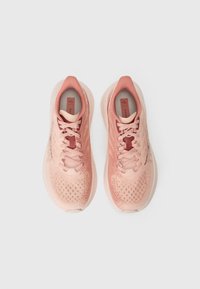 Helle rosa Sportschuhe mit einem atmungsaktiven Mesh-Obermaterial, strukturierten Oberflächen und passenden Schnürsenkeln. Abgerundete Zehenpartie und gepolsterte Sohle.