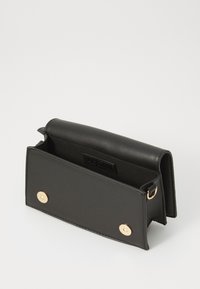 Clutch de cuero negro con textura suave, herrajes dorados y cierre a presión. Presenta un interior espacioso y un diseño minimalista.