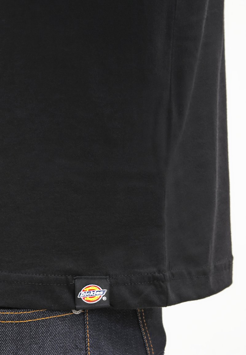 T-shirt nera in cotone a maniche corte, con orlo cucito e etichetta con logo Dickies in fondo. Design standard con collo a giro.