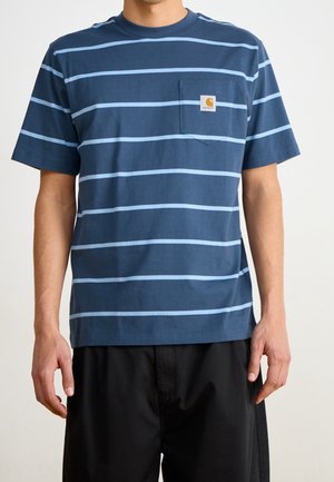 Homme portant un t-shirt bleu marine avec des rayures horizontales bleu clair et une petite poche poitrine avec un logo Carhartt.
