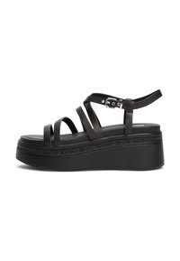 Sandales à plateforme noires avec plusieurs sangles, boucle de cheville ajustable, et semelle texturée comportant la marque "TOMMY JEANS" sur le côté.