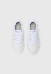 Pair of white Puma sneakers with laces, viewed from above on a plain white background.