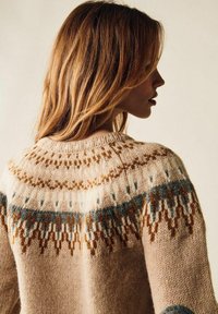 Stickad tröja med en beige grund, flerfärgad mönster yoke i brunt och blått, rund halsringning och en strukturerad yta.