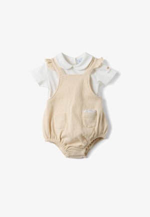 Cremefarbener, strukturierter Overall mit zwei aufgesetzten Taschen vorne und daran befestigtem weißen Kurzarmhemd mit Peter-Pan-Kragen und gerafften Schulterträgern.