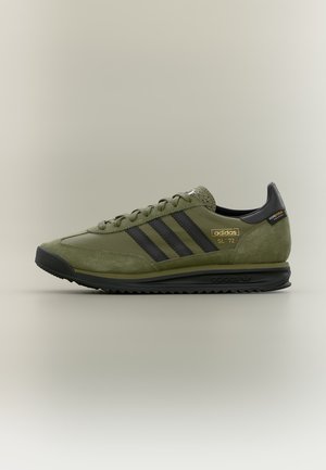 Baskets Adidas SL '72 vert olive avec des bandes noires, semelle noire et détail de marque doré sur fond clair.