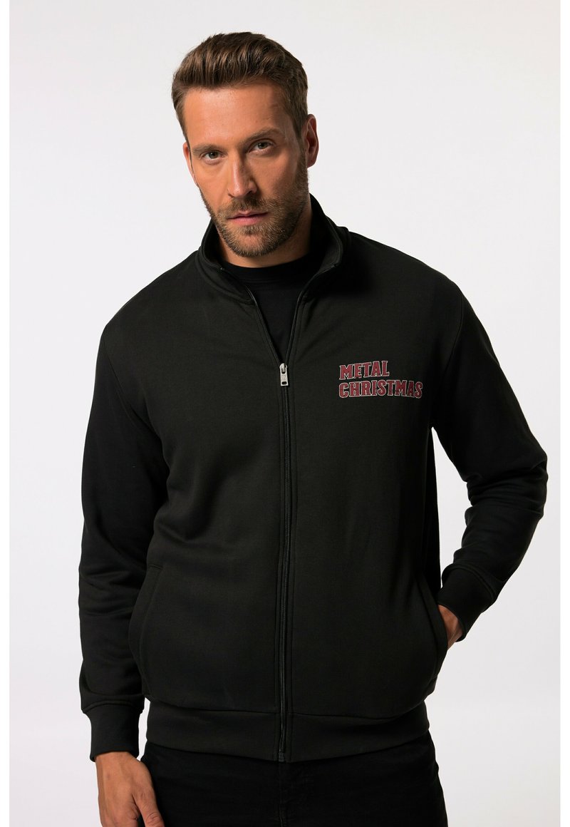 Sudadera negra con cremallera hecha de una mezcla de algodón, con la inscripción "NAVIDAD METÁLICA" bordada en rojo en el lado izquierdo del pecho. Textura suave.