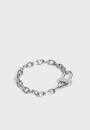 Silbernes Kettenarmband mit ovalen Gliedern und einem kleinen Verschluss mit der Gravur des Wortes "BOSS" auf einem einfarbigen hellen Hintergrund.